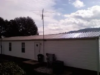 New metal roof on a single wide mobile home with a TV antenna in Napoleonville
