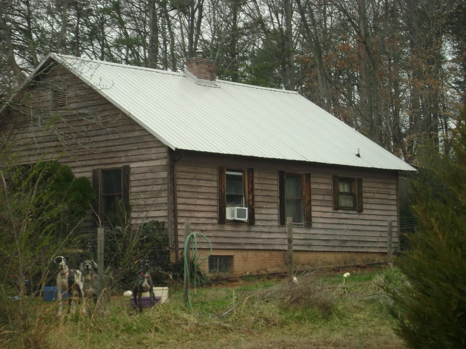 White metal roof on an old wood sided farmhouse, from a Metal Roof Installation job in Napoleonville